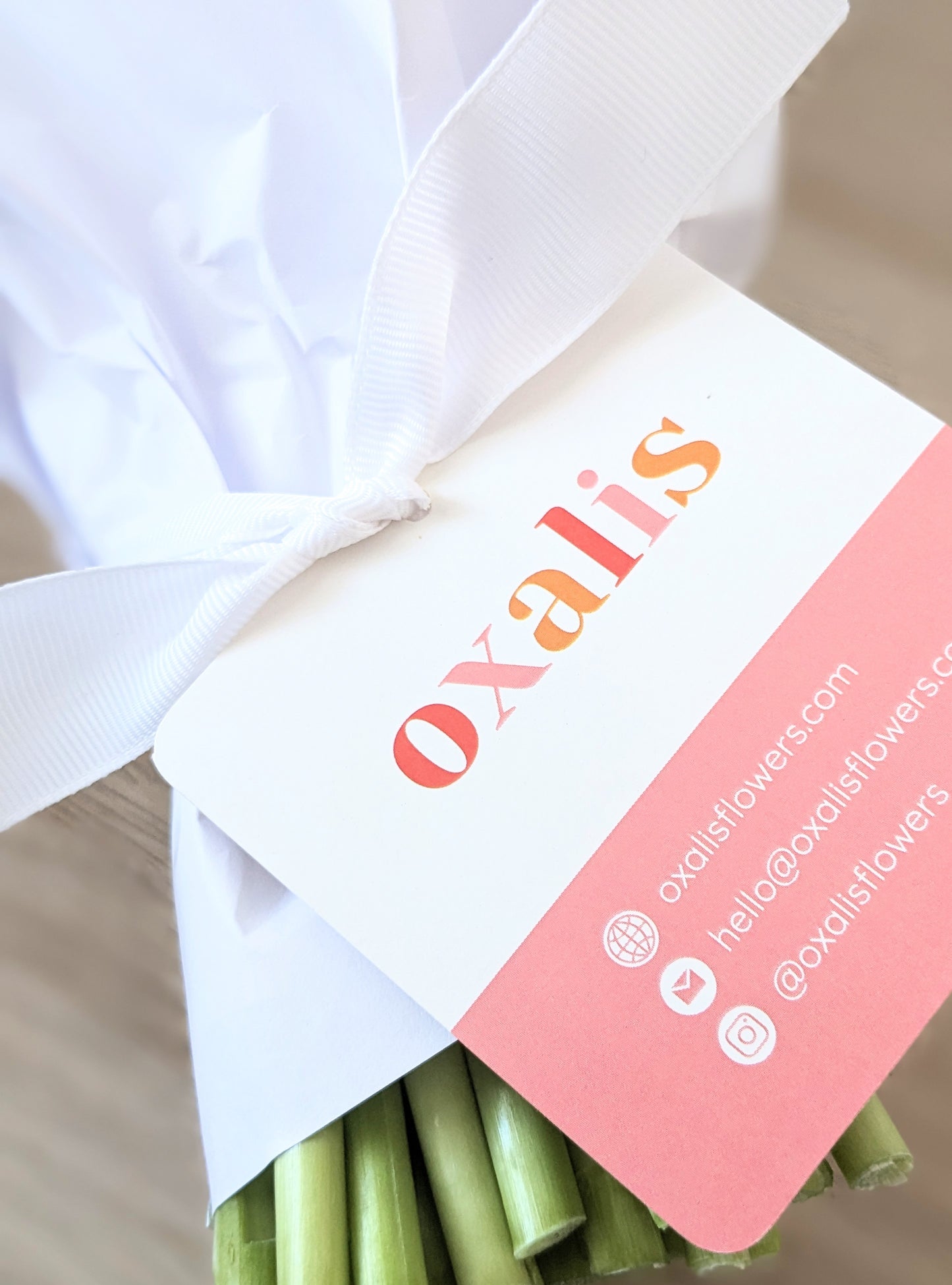 Bouquet of flowers with Oxalis Flowers hangtag showing contact details
